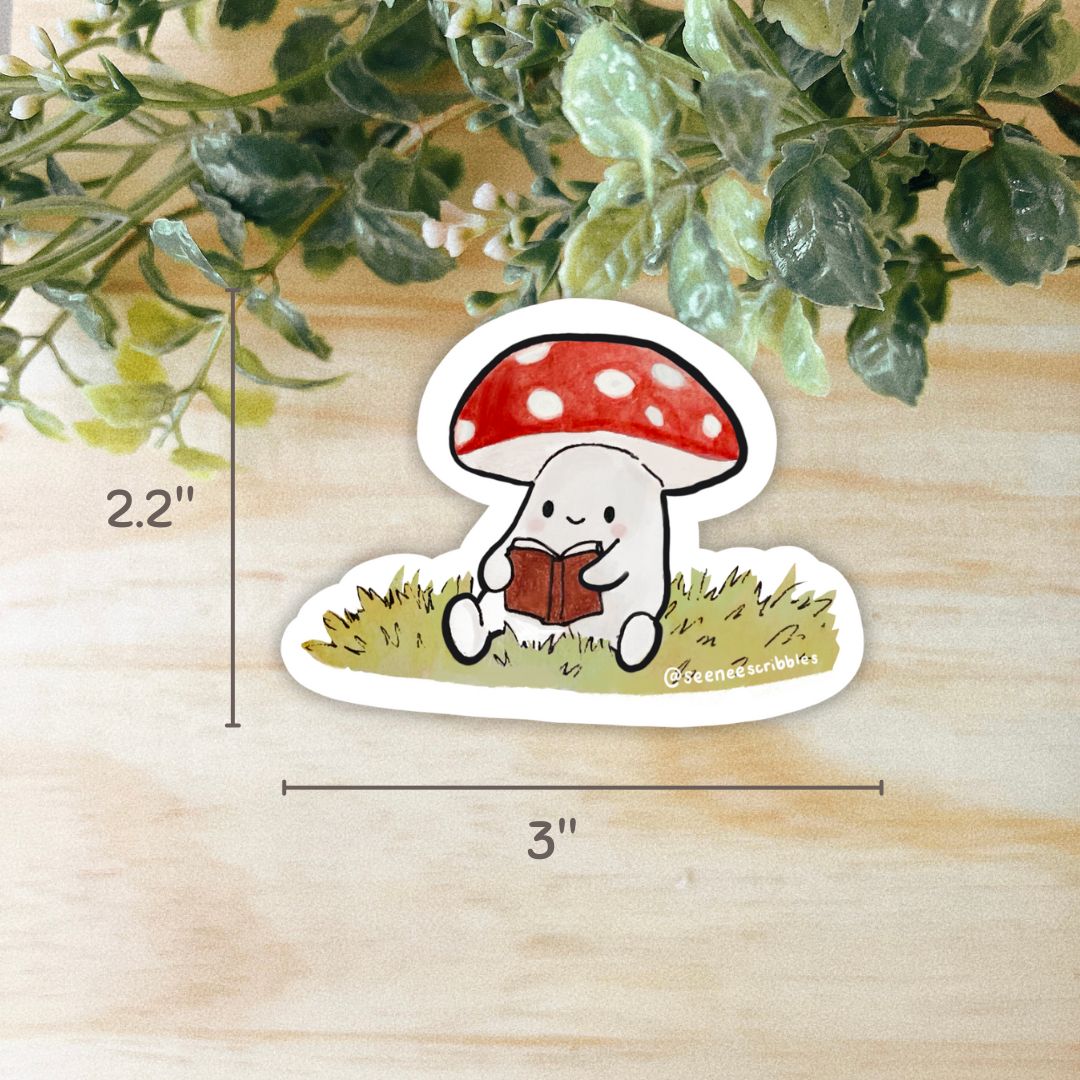 Weatherproof vinyl sticker of a mushroom reading a book, sitting on grass. Dimensions are shown as 2.2 inches high and 3 inches wide.