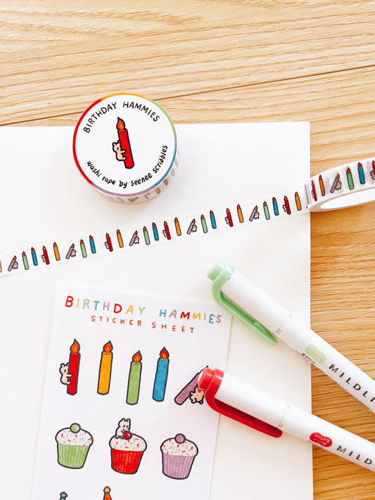 Washi tape with colorful illustrations of birthday candles, a matching sticker sheet, and markers on a wooden surface